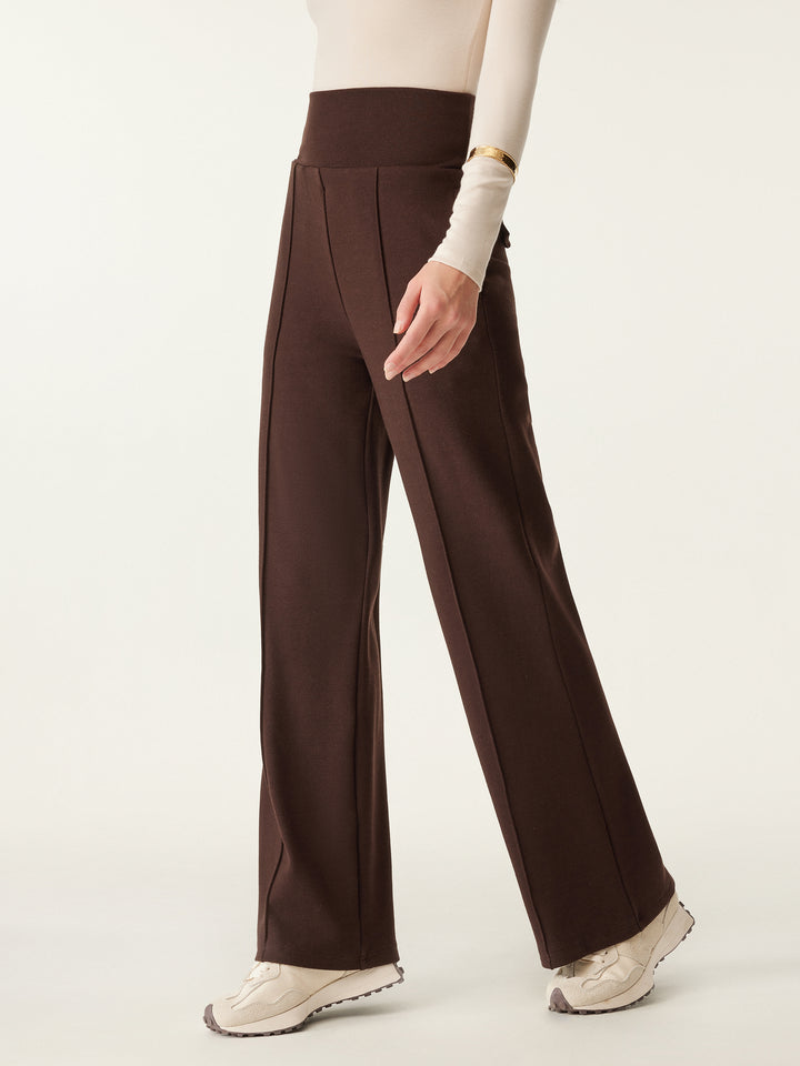 walking woman in wide waistband pintuck pants